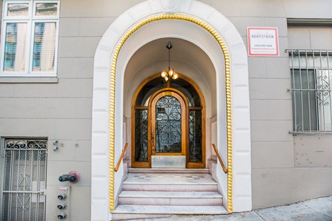 A building with a brown door and a sign that says "Rent now".