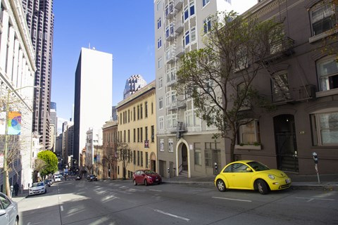 A yellow car is parked on the side of a street.