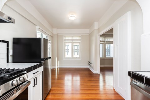 A kitchen with a black stove top oven and a black fridge.