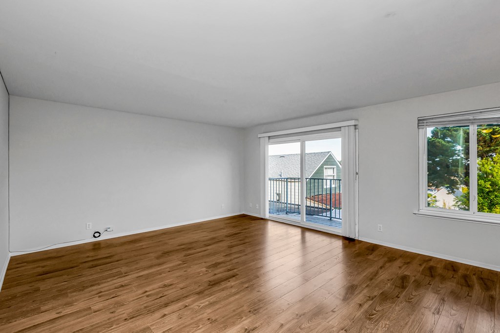 A room with wooden flooring and white walls.