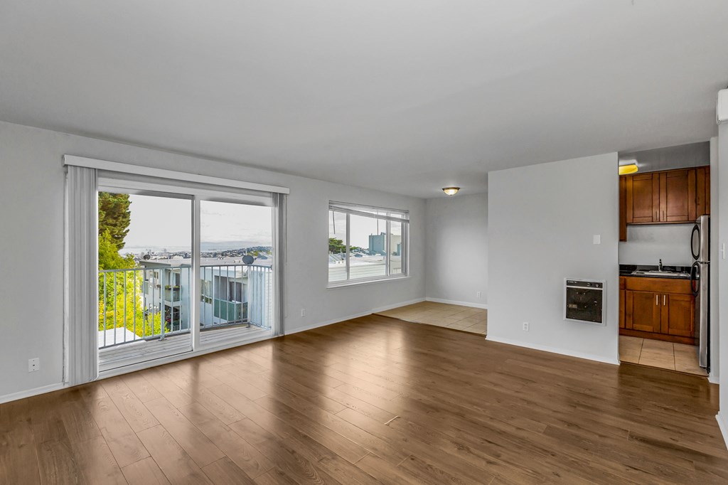 A large empty room with wooden floors and white walls.