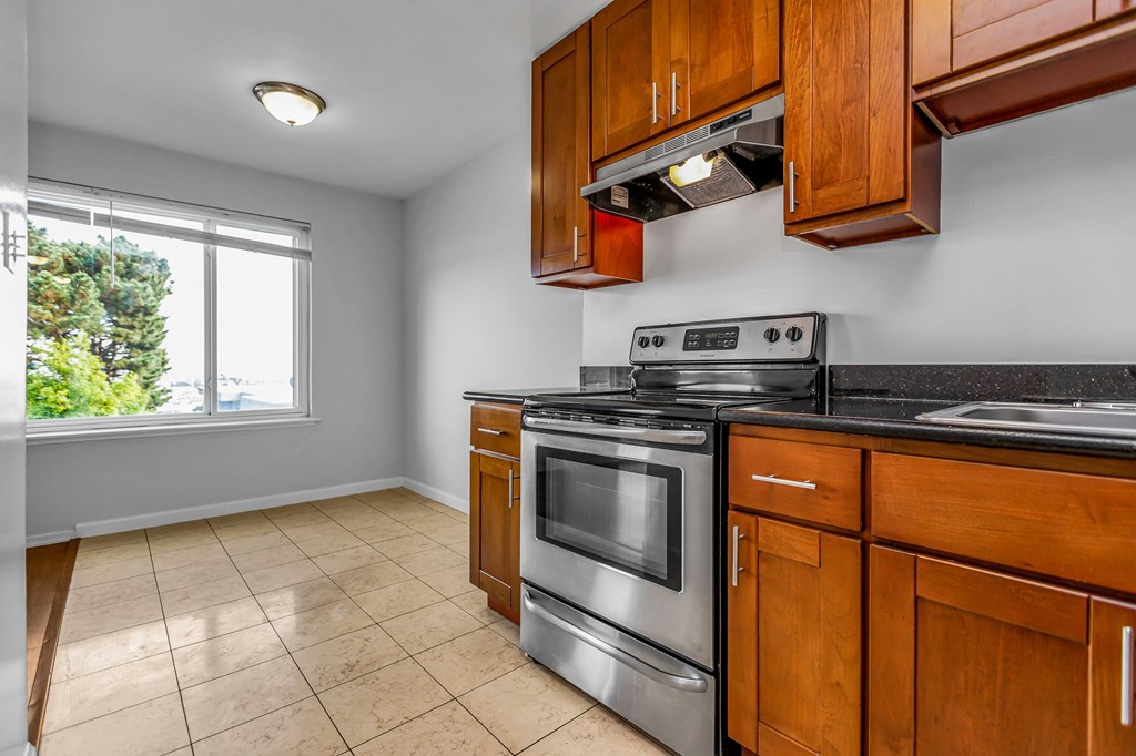 A kitchen with wooden cabinets and a black stove top oven.