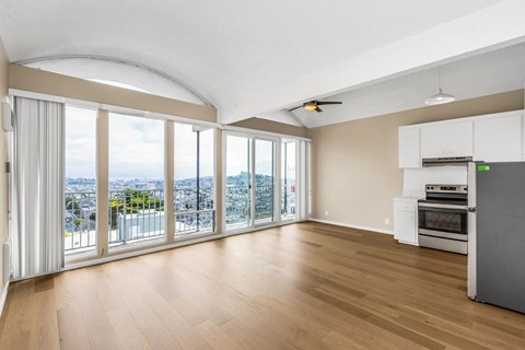 A spacious living room with a view of the cityscape outside the large windows.