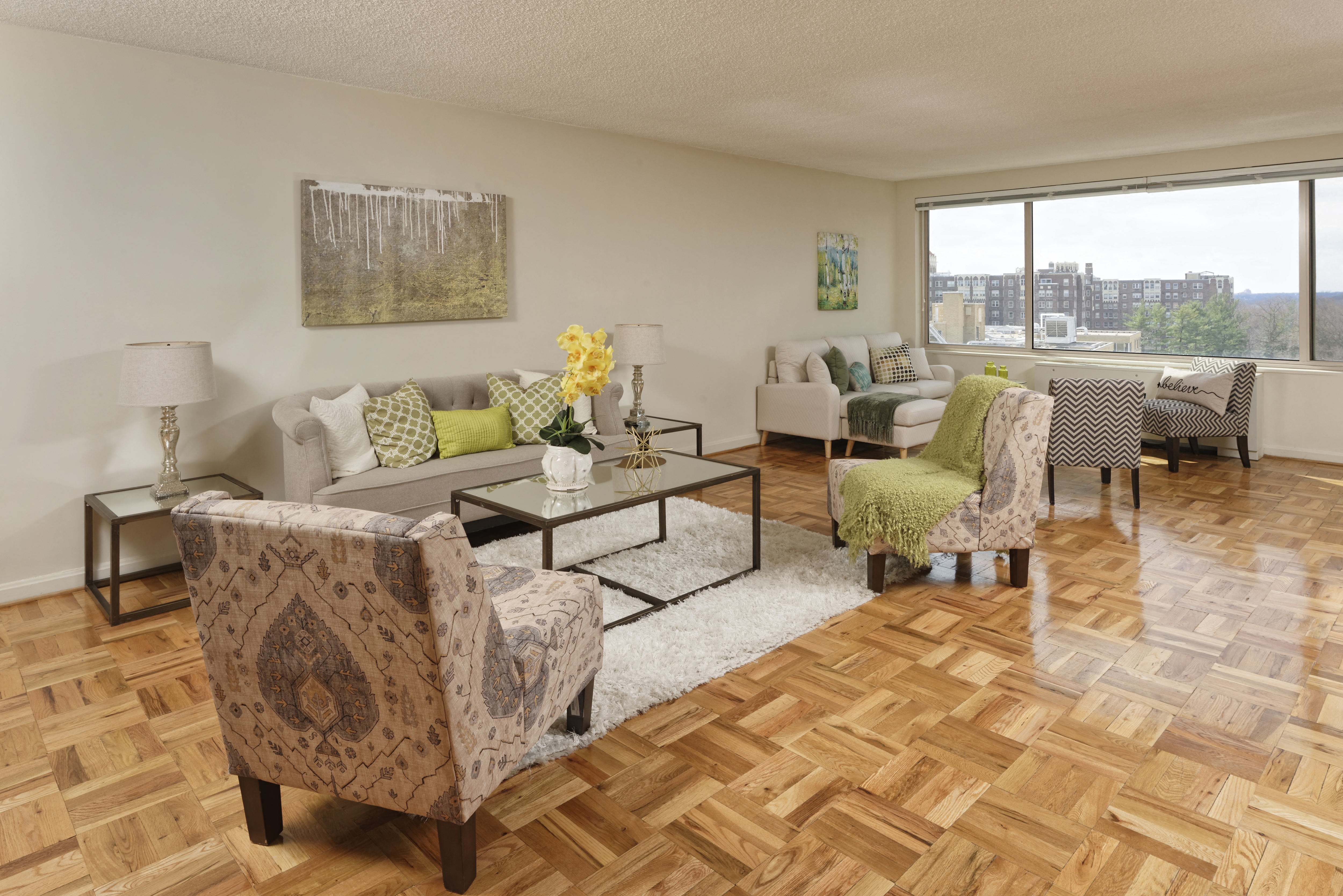 A living room with a patterned chair and a glass coffee table.