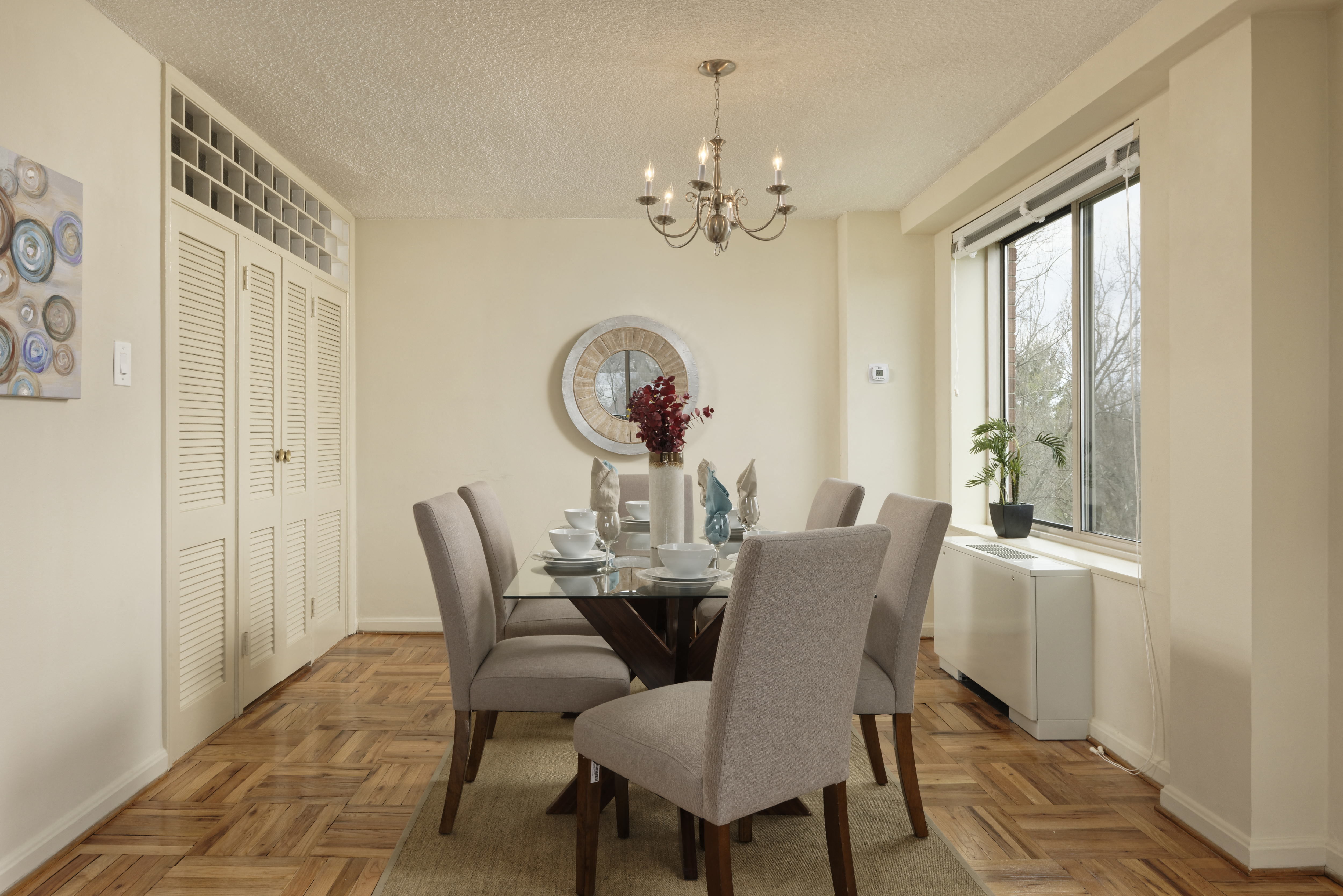 Elegant dining room with glass table and chandelier at 4000 Massachusetts Avenue Apartments, Washington, DC 20016