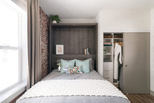 A bedroom with a large bed and a brick wall.