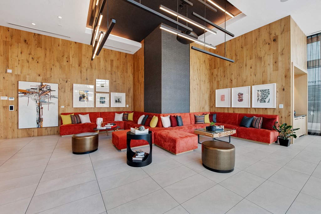 the lobby of a building with a red couch and tables