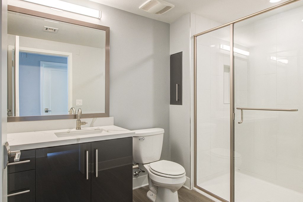 a bathroom with a toilet and a sink and a shower