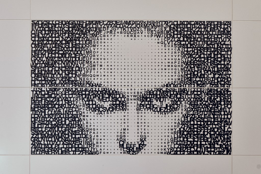 a black and white drawing of a face on a white wall