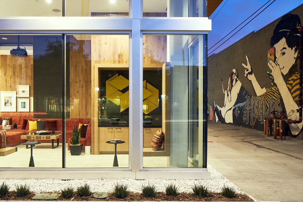 a lobby with a mural on the wall and glass doors