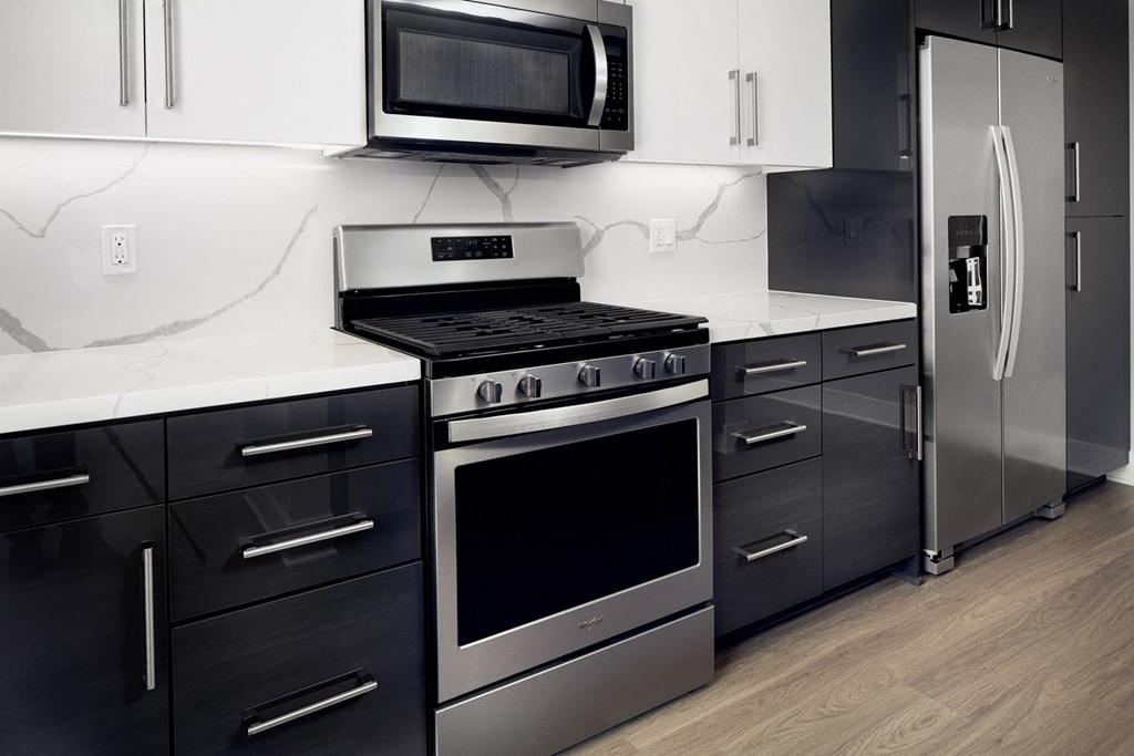 a black and white kitchen with stainless steel appliances and a microwave