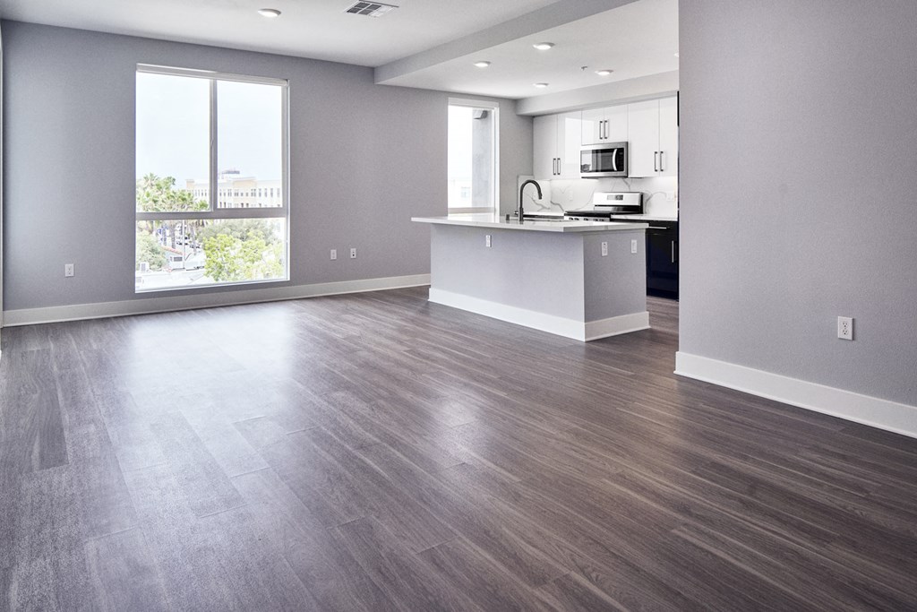 the living room and kitchen of an empty apartment