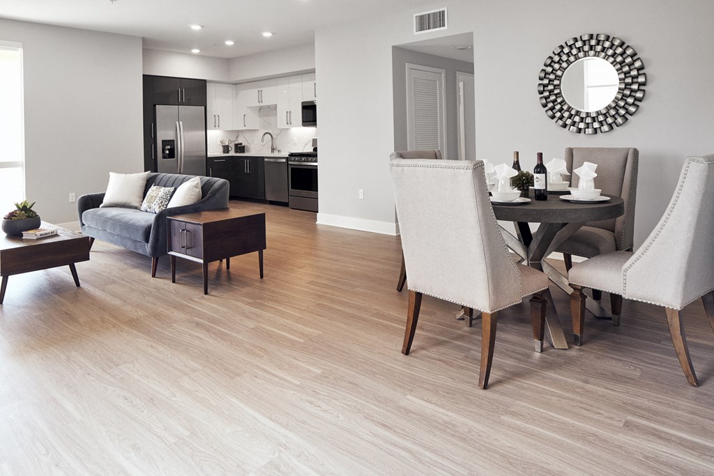 a renovated living room and dining room with a wood floor