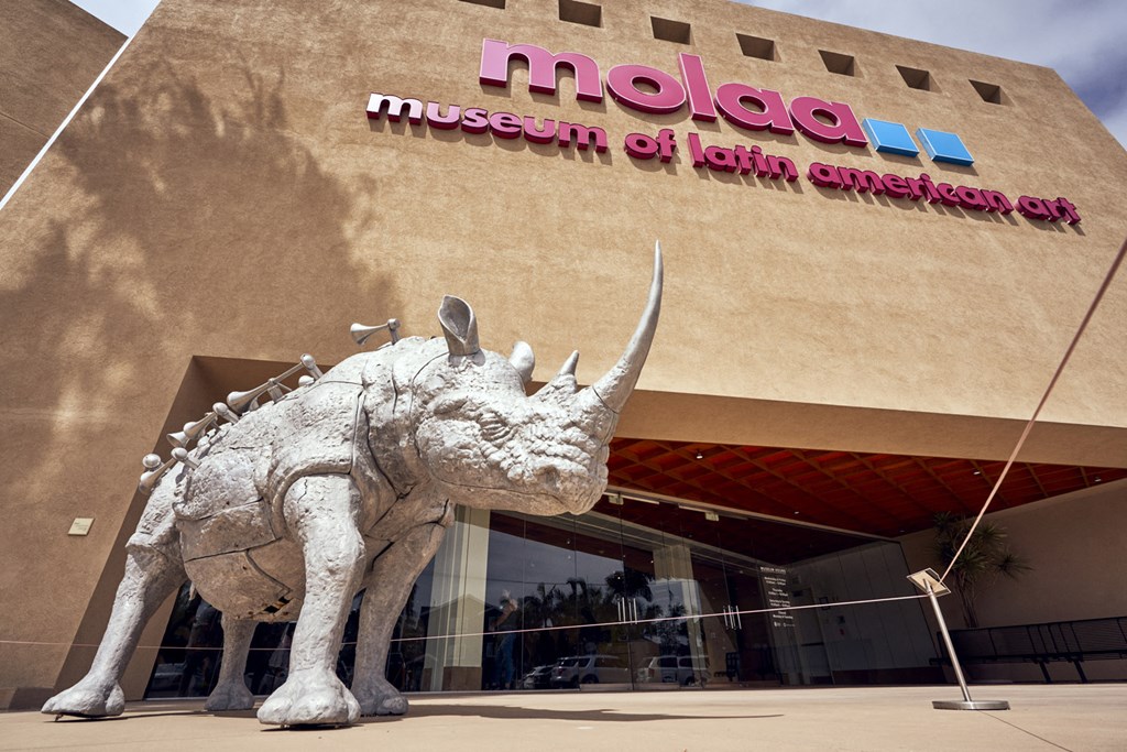 a sculpture of a dinosaur in front of a museum art