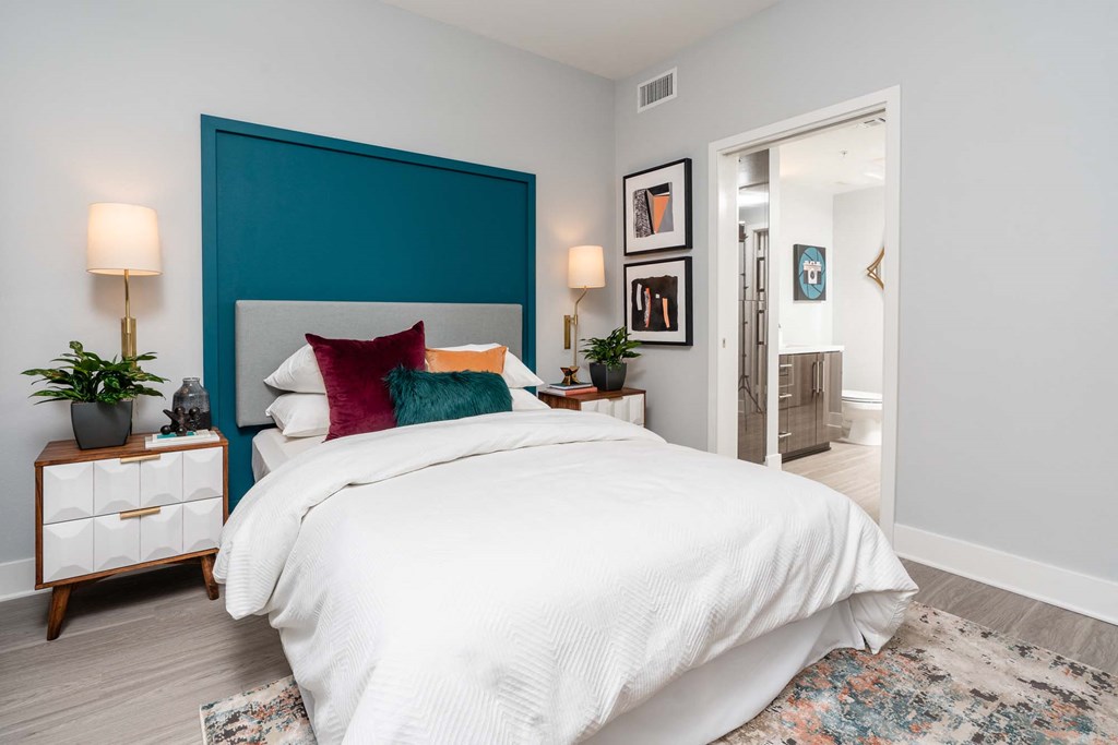 a bedroom with a blue headboard and a white bed