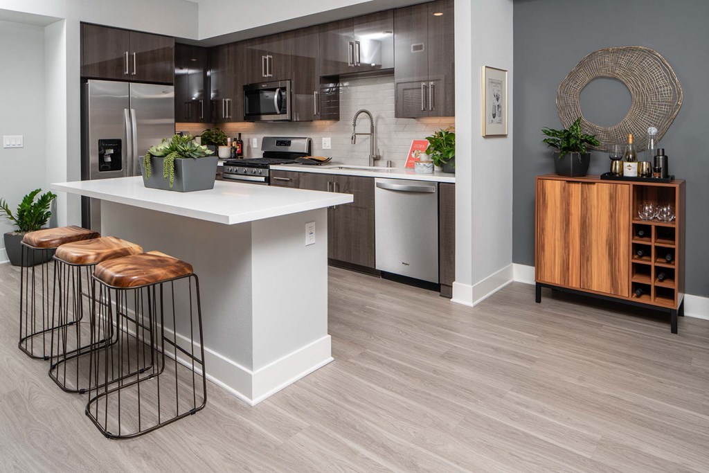 a kitchen with a counter and stools in front of a