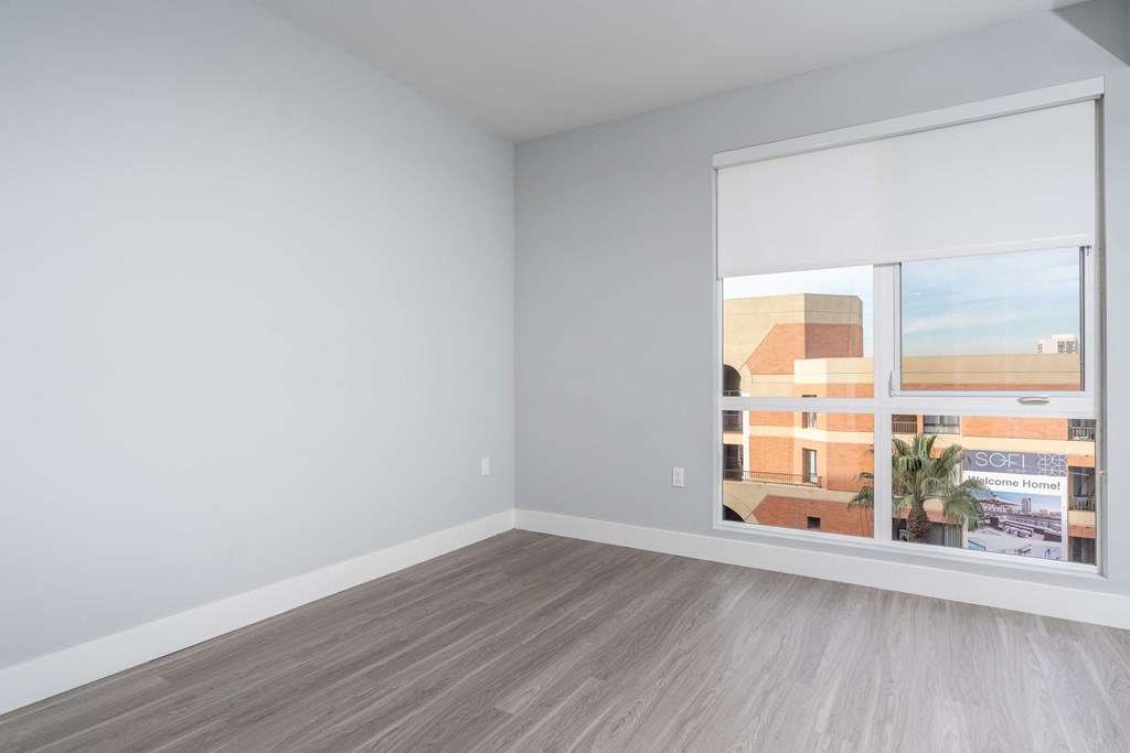 an empty room with a large window and wood floors