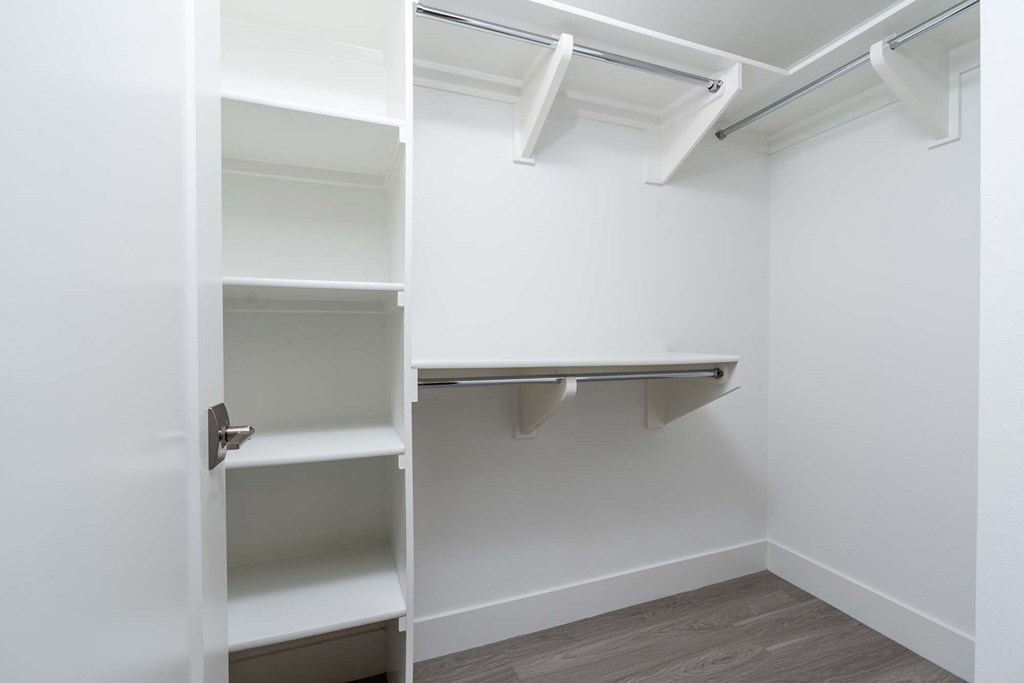 a walk in closet with shelves and a door