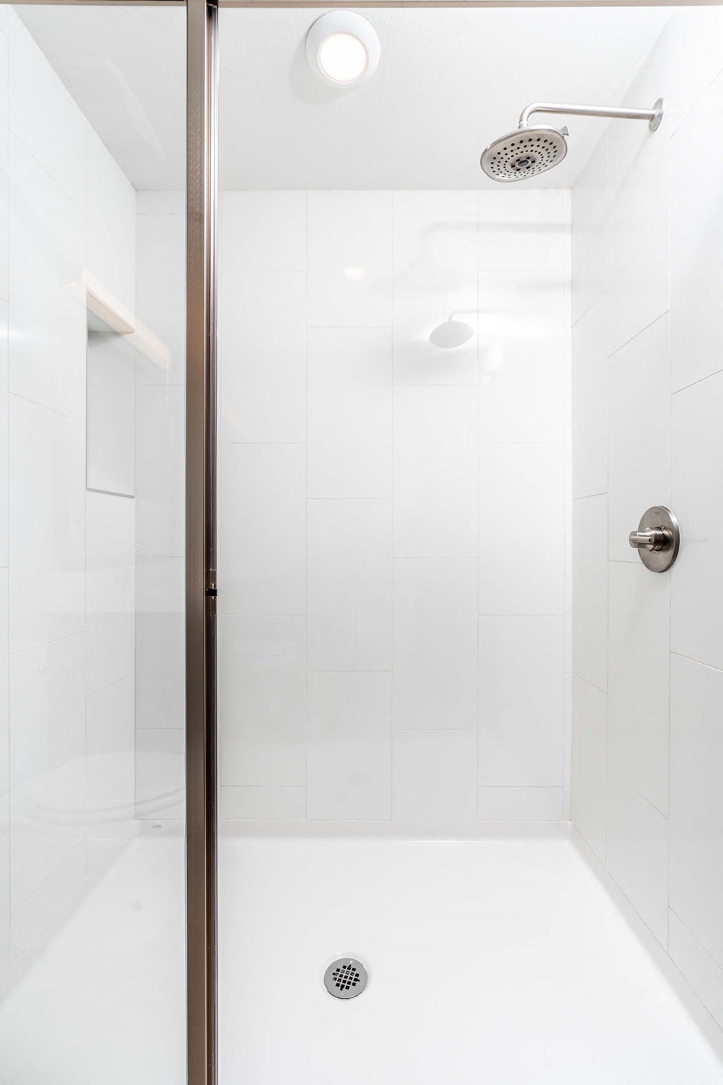 a white bathroom with a shower with a glass door