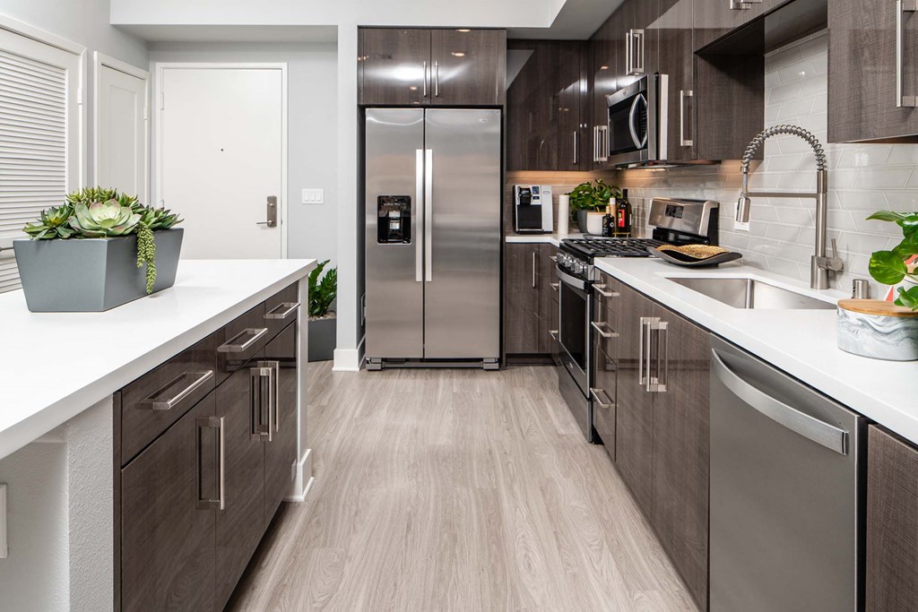 a modern kitchen with stainless steel appliances and wooden cabinets