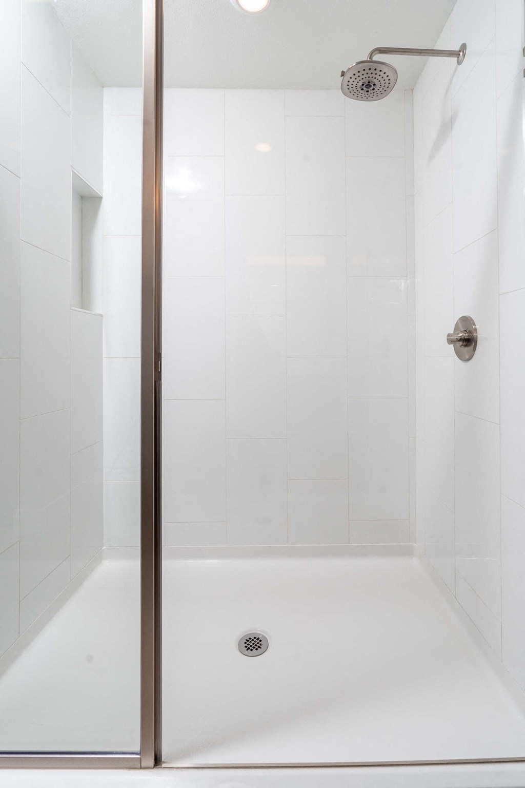 a white bathroom with a shower with a glass door