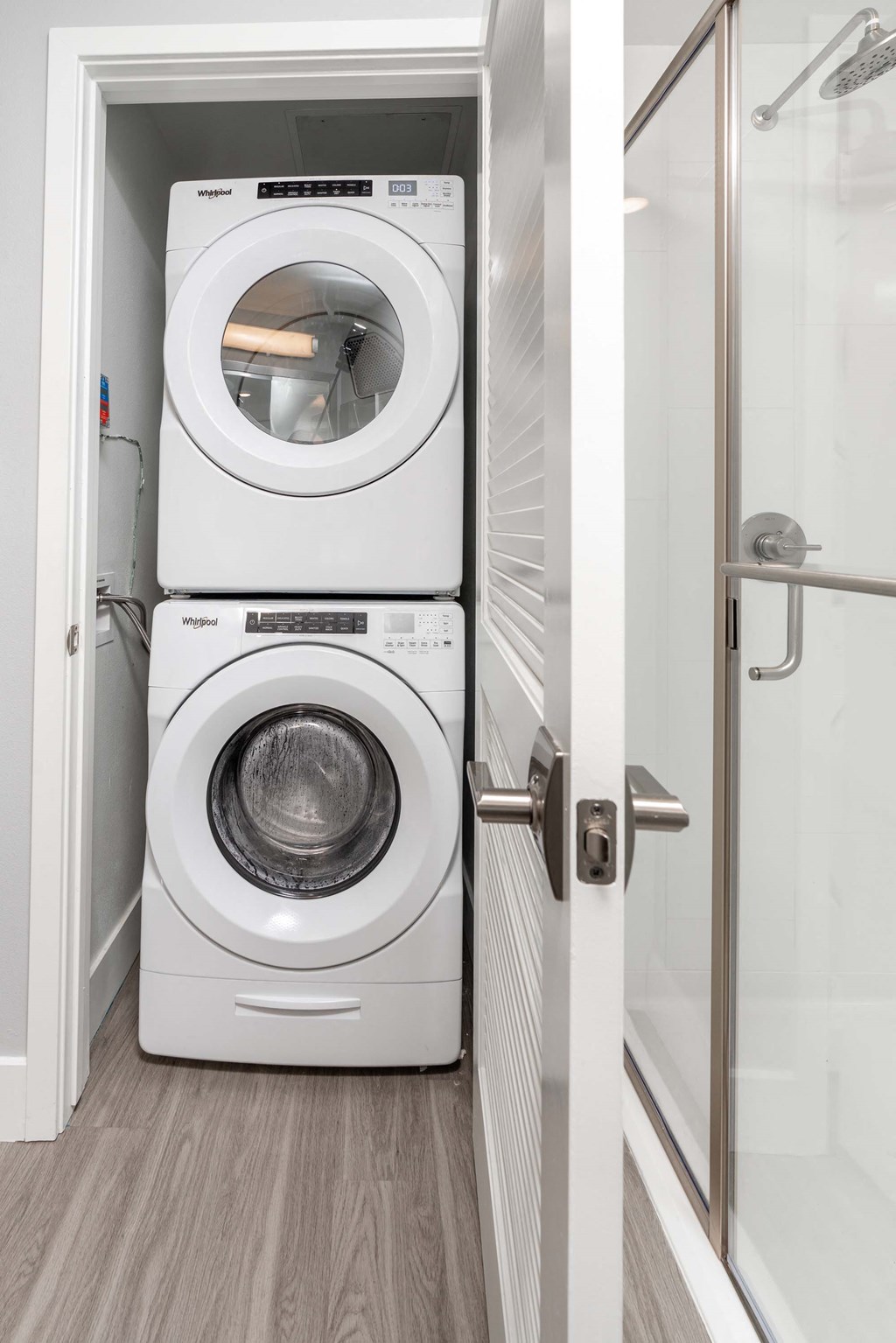 a white washer and dryer in a bathroom next to a shower