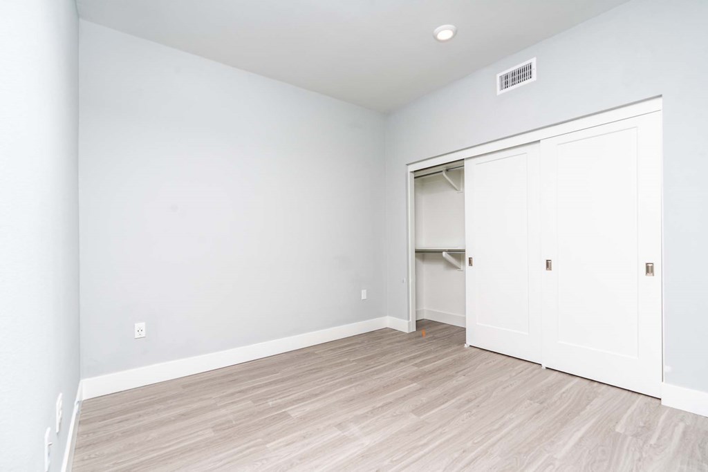 an empty room with white walls and a closet