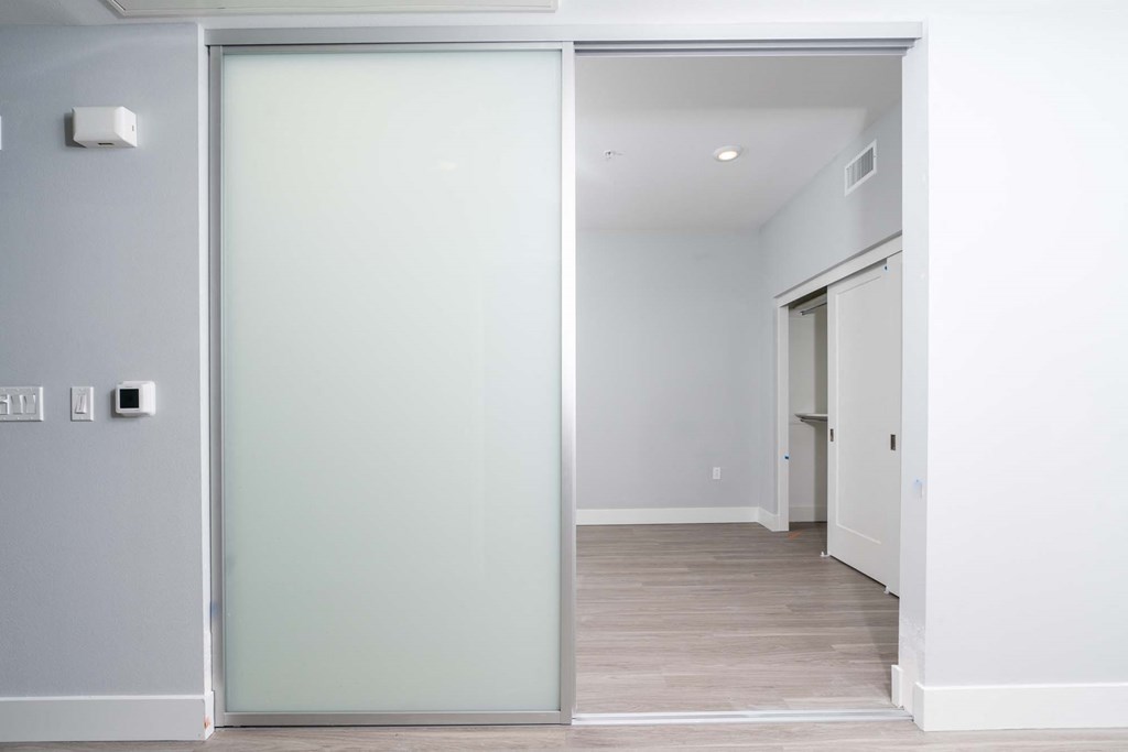 a sliding glass door leading to a hallway with a closet