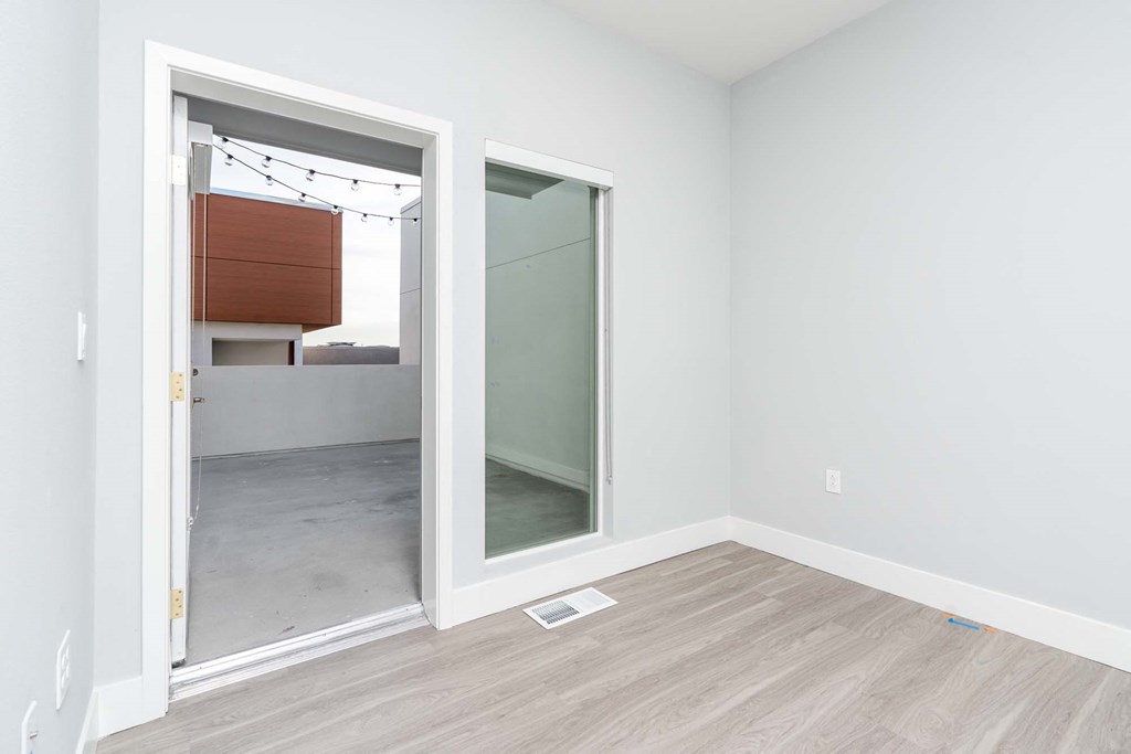 an empty room with a door to a bathroom with a mirror