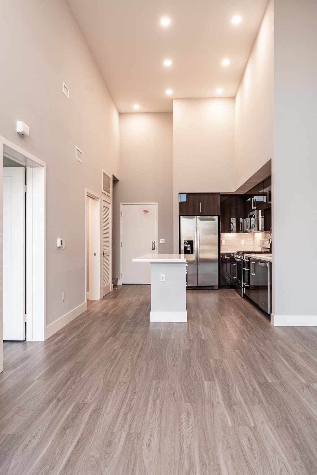 a renovated living room and kitchen with a wood floor