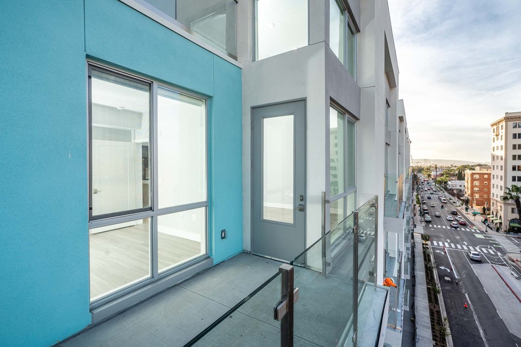 a balcony with views of a city street and a blue building