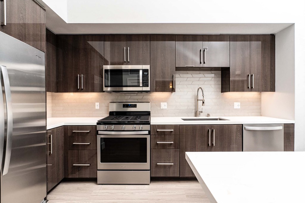 a modern kitchen with stainless steel appliances and wooden cabinets