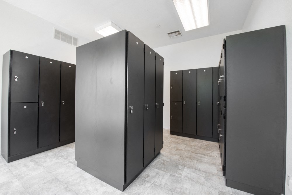 a row of black urinals and stalls in a public restroom