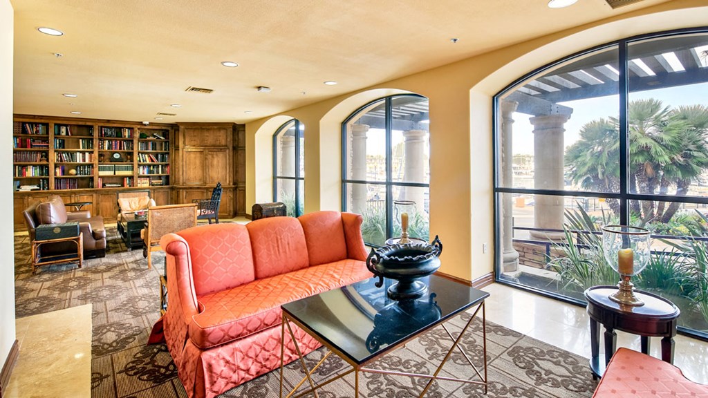 a living room with large windows and a orange couch