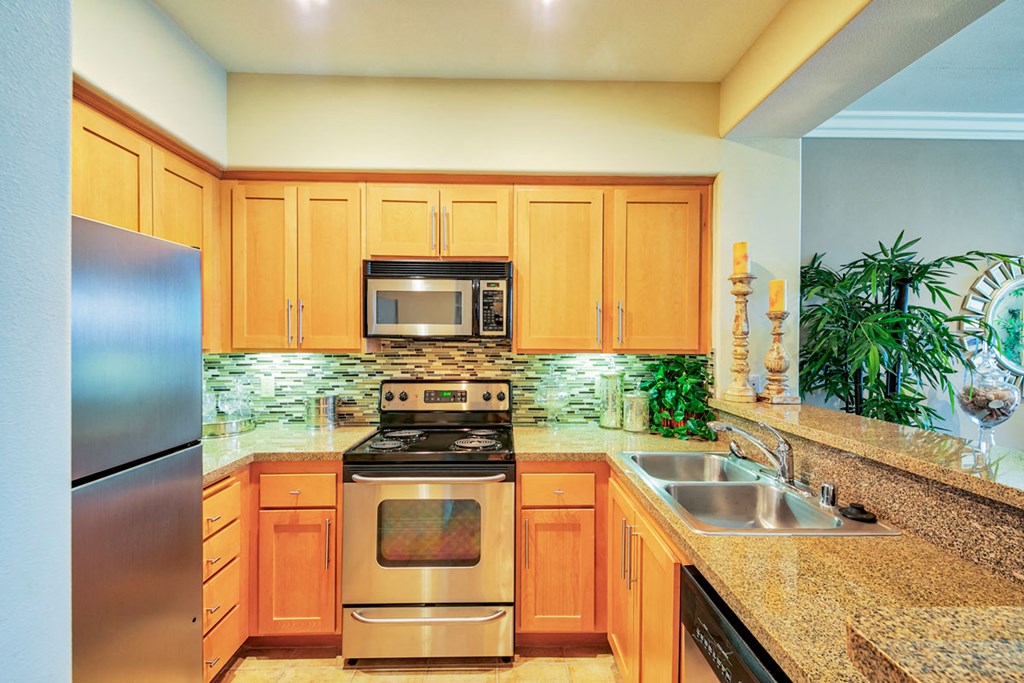 a large kitchen with stainless steel appliances and granite counter tops