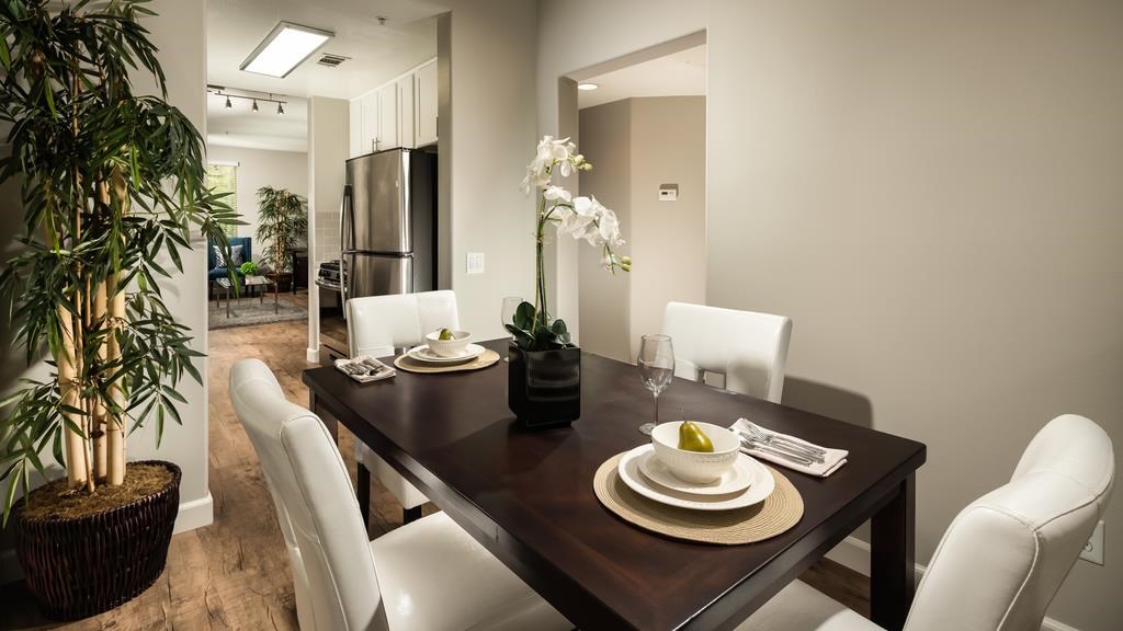 a dining room with a wooden table and white chairs