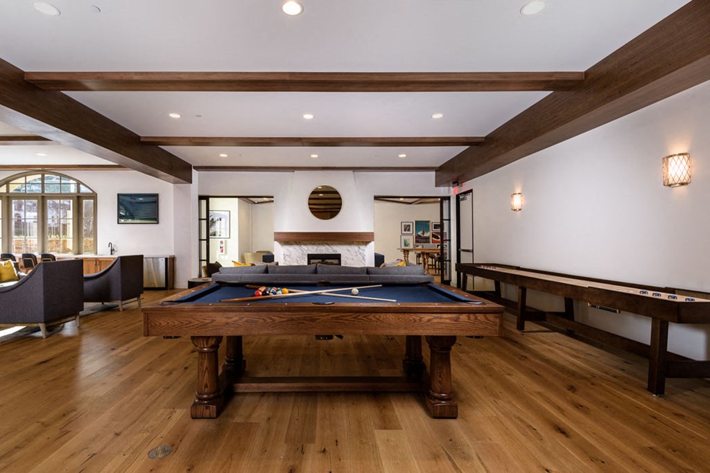 a game room with a pool table and other games