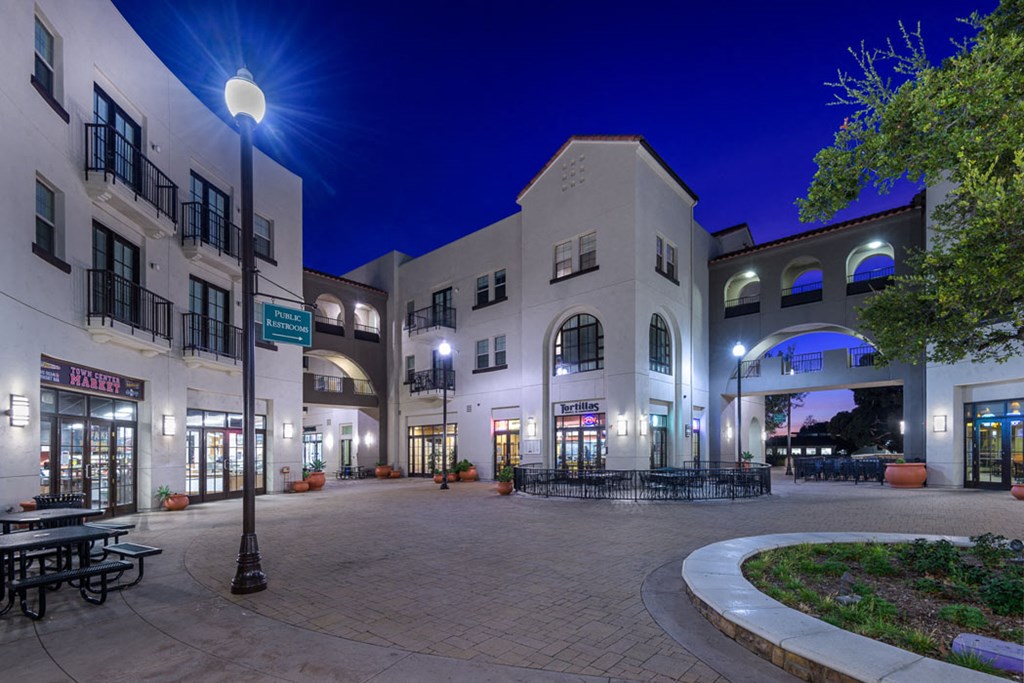 a city at night with buildings and a courtyard