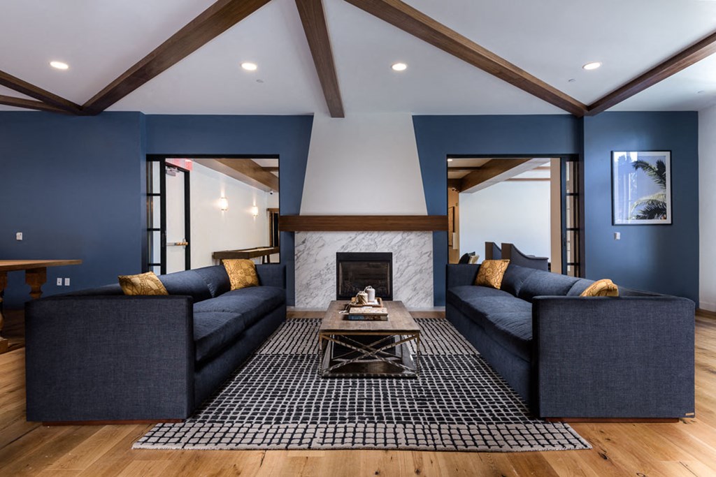 a living room with blue couches and a fireplace