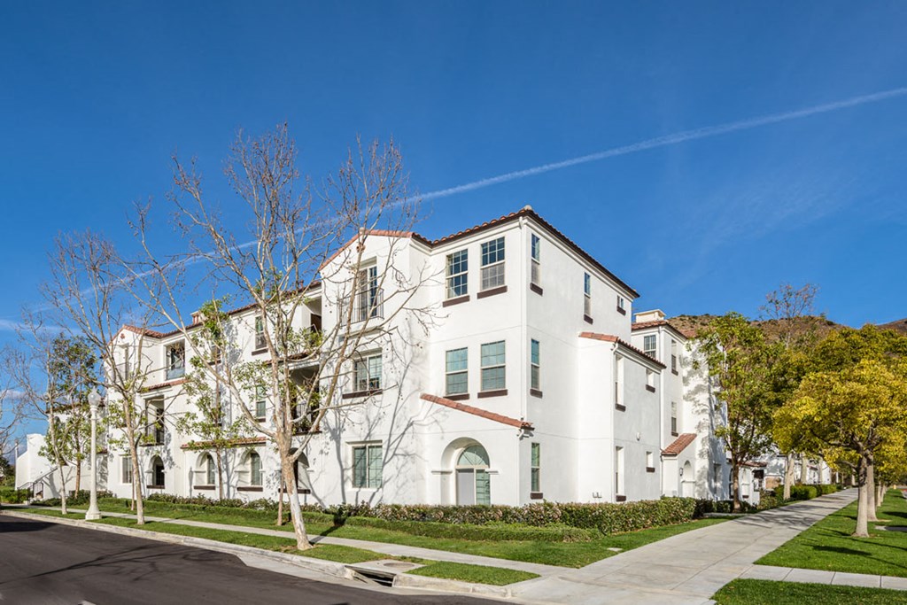 a row of white apartment buildings on the side of a street