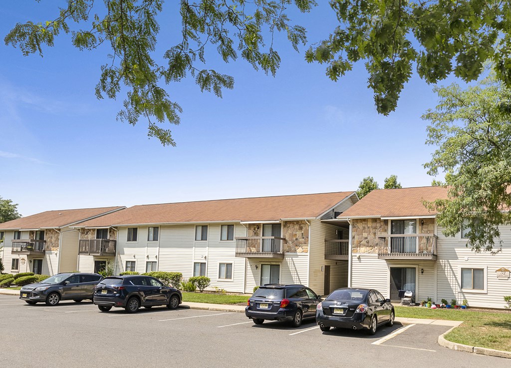 a parking lot in front of an apartment building with cars parked