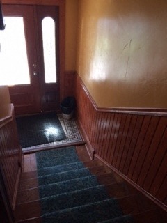 a small room with a door and some rugs