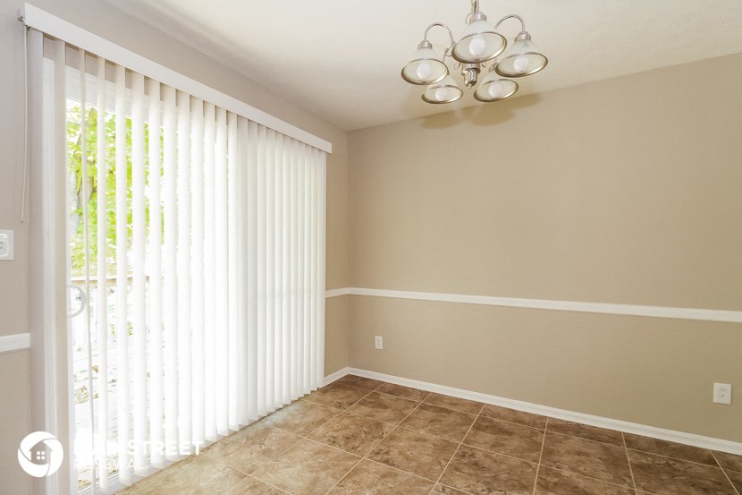 a living room with a large window with white blinds and a ceiling fan