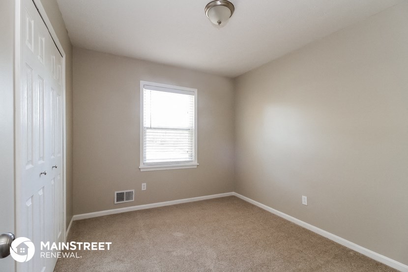 an empty room with a window and a white door