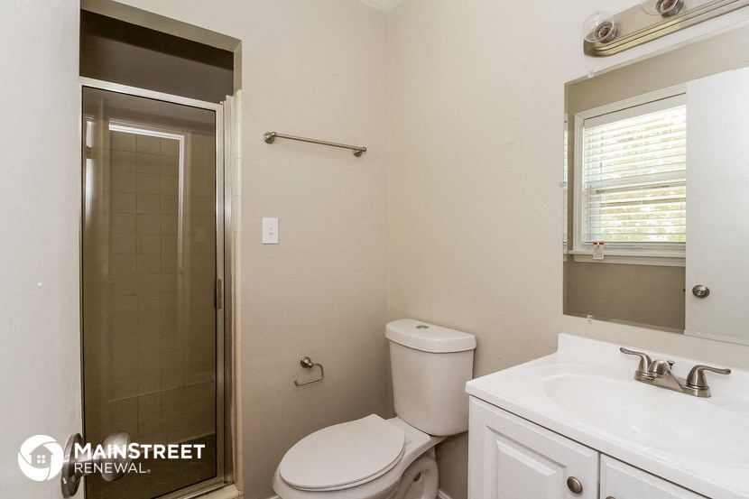a bathroom with a toilet and a shower and a sink