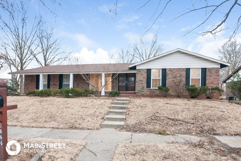 a brick house with a sidewalk in front of it