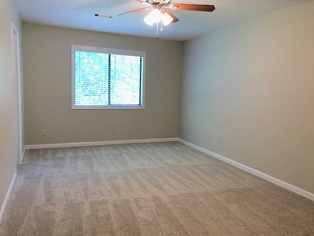 an empty room with a window and a ceiling fan