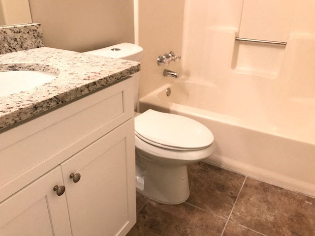 a bathroom with a toilet and a tub and a sink