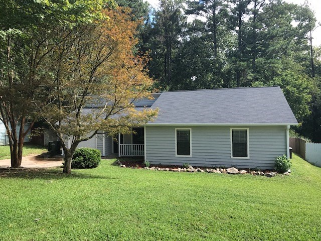 a house with a yard and a tree in front of it