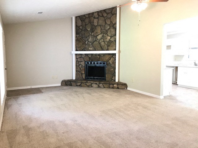 an empty living room with a stone fireplace